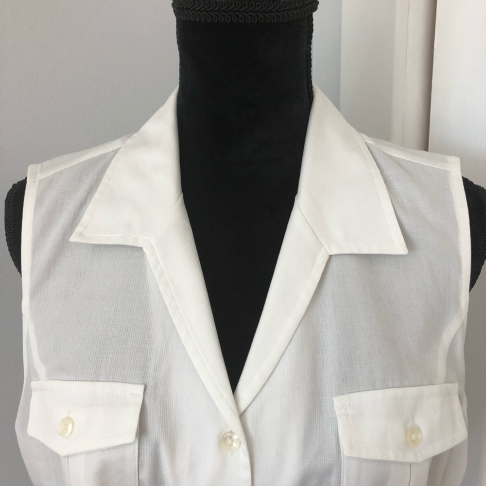Sleeveless, collared and belted top.